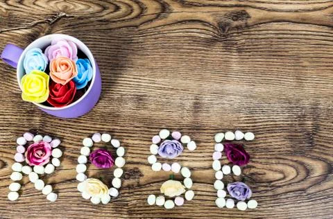 Cup of button roses with the text rose formed with marshmallows on wooden tab Stock Photos