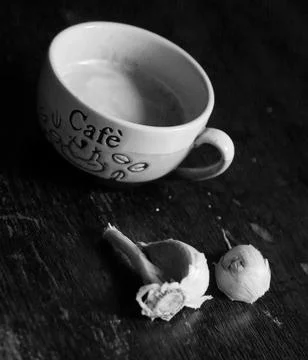 A cup with cafe written on it is empty on a wooden table. Pieces of fruit and Foto stock