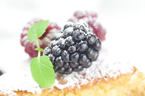 Cup, cake, raspberry, blackberry,nuts and mint on a plate on a white backgrou Foto stock