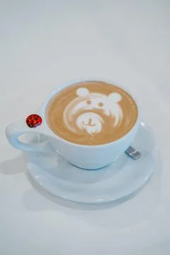 Cup of cappuccino with a bear pattern on white background Stockfoto's