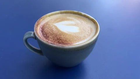 Cup of cappuccino on a blue table Video stock 310491790