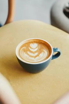 A cup of cappuccino placed on a table Stock Photos