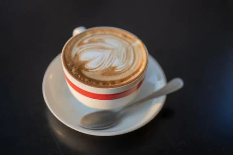 A cup of cappuccino with a spoon Stock Photos