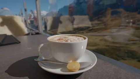 Cup of cappuccino on table in cafe overlooking mountains Stock Footage 228879225