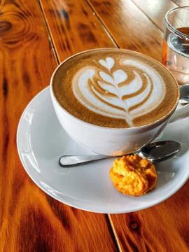 Cup of cappuccino on a textural brown table with cookies, free space. Stock Photos