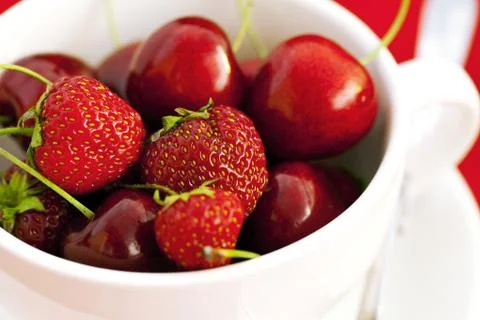 Cup  cherry and strawberry on a red background Stock-Fotos