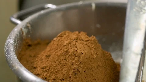 Cup of cocoa is added to large mixing bowl in slow motion Stock-Footage 94254356