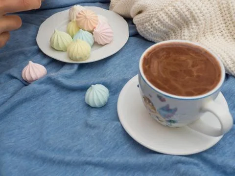Cup of cocoa with foam and multi-colored bise on a wooden table Stock Photos