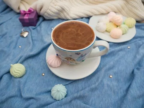 Cup of cocoa with foam and multi-colored bise on a wooden table Foto stock