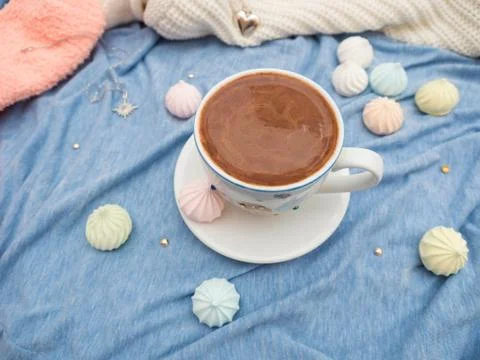 Cup of cocoa with foam and multi-colored bise on a wooden table Stock Photos