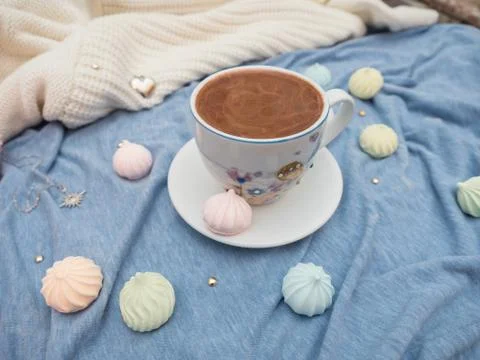 Cup of cocoa with foam and multi-colored bise on a wooden table Stock Photos
