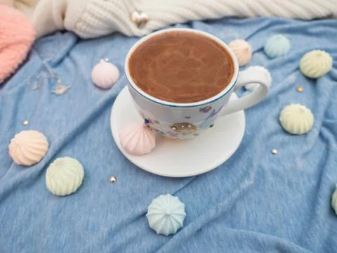 Cup of cocoa with foam and multi-colored bise on a wooden table Stock Photos