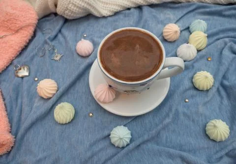 Cup of cocoa with foam and multi-colored bise on a wooden table Stock Photos