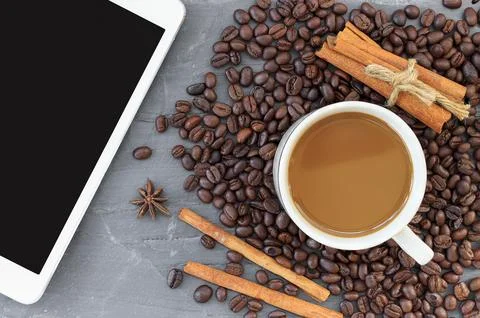 Cup of coffe, coffee beans and tablet computer on stone background Stock Photos