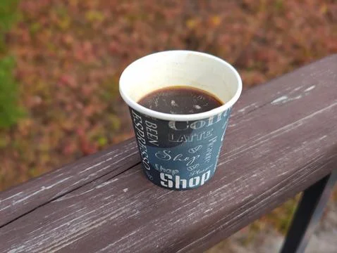A cup of coffee against the backdrop of bright autumn nature Stock Photos