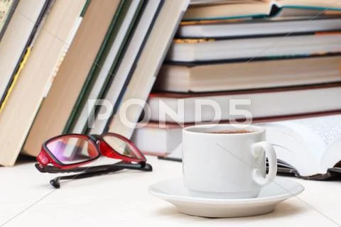 Cup of coffee on against the background of the books Stock Photos