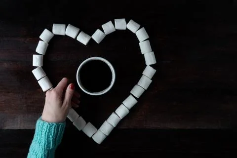 Cup of coffee among marshmallows in shape of heart on wooden dark surface Stock Photos