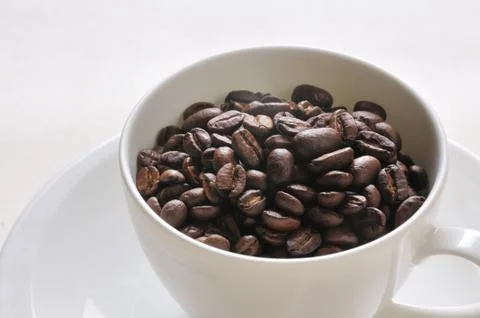 A cup of coffee and beans on the table. Stock Photos