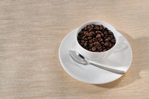 A cup of coffee and beans on the table. Stock Photos