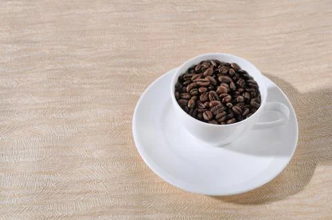 A cup of coffee and beans on the table. Stock Photos