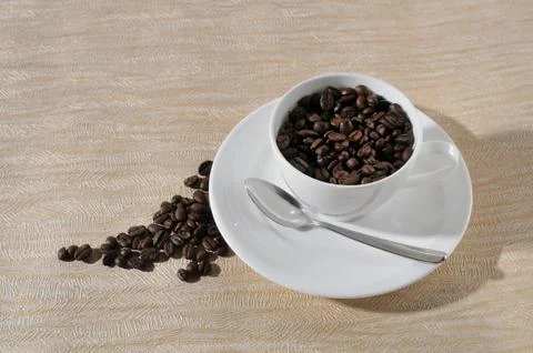 A cup of coffee and beans on the table. Stock Photos