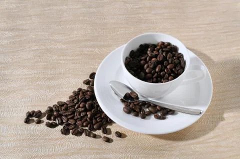 A cup of coffee and beans on the table. Stock Photos