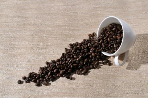 A cup of coffee and beans on the table. Stock Photos