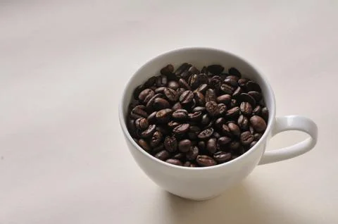 A cup of coffee and beans on the table. Stock Photos
