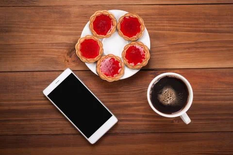 Cup of coffee and biscuits cell phone on the table. Stock Photos