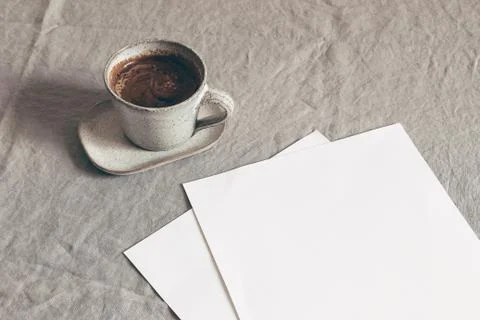Cup of coffee and blank sheets of paper. Moody breakfast table stationery mockup Stock-Fotos