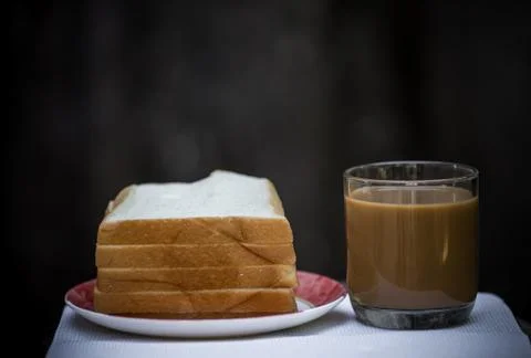 A cup of coffee and bread with a gray background. Foto stock