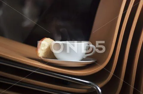 A cup of coffee and brioche on an office chair Stock-Fotos