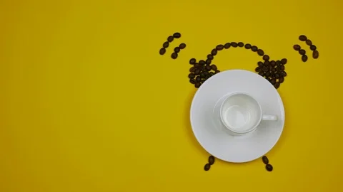 A cup of coffee and coffee beans forming an alarm clock on the yellow background Stock Footage 92371975