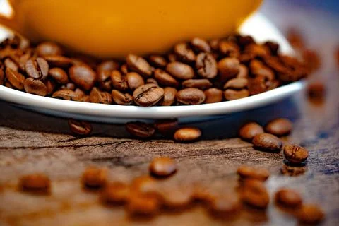 Cup of coffee and coffee beans on a white plate. dark background Fotos Stock