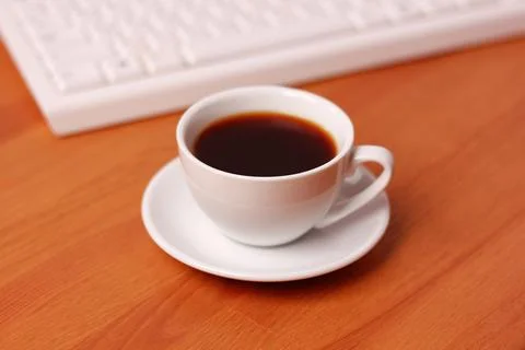 A cup of coffee and a computer keyboard Stock Photos