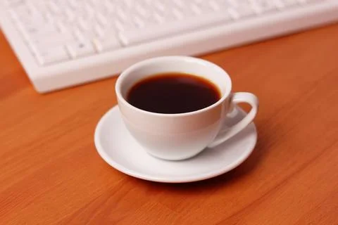A cup of coffee and a computer keyboard Stock Photos