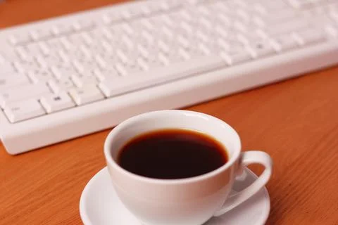 A cup of coffee and a computer keyboard Stock-Fotos