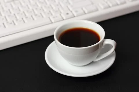 A cup of coffee and a computer keyboard 스톡 사진