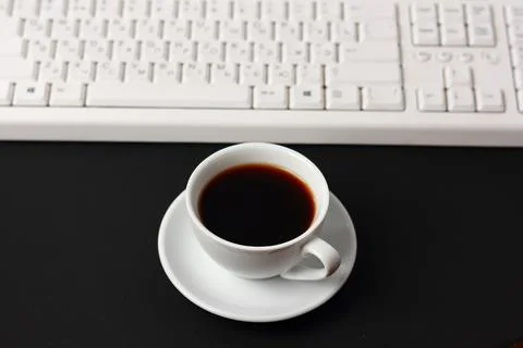 A cup of coffee and a computer keyboard Stock Photos
