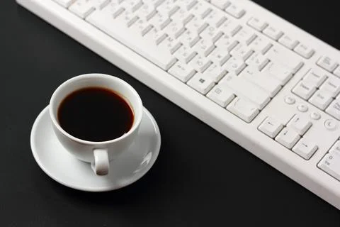 A cup of coffee and a computer keyboard Stock Photos