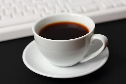 A cup of coffee and a computer keyboard Stock Photos
