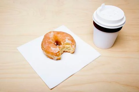 Cup of coffee and donut with missing bite Stock Photos
