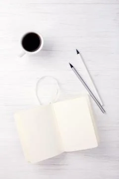 A cup of coffee and notebook on the table. Stock Photos