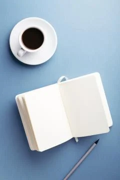 A cup of coffee and notebook on the table. Stock Photos
