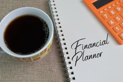 A cup of coffee and notebook written with FINANCIAL PLANNER Stock Photos