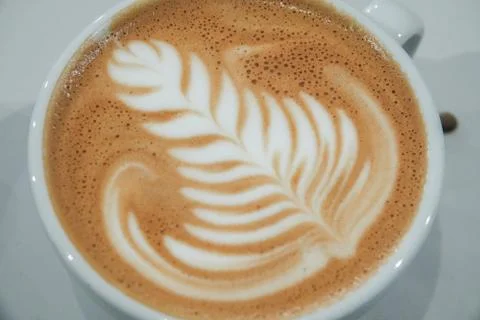 A cup of coffee and a pattern on milk foam. Stock Photos