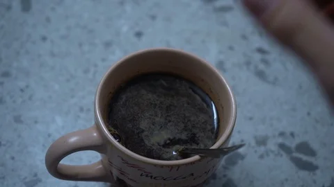 Cup of coffee and a spoon in hand of a woman Stock Footage 104360636