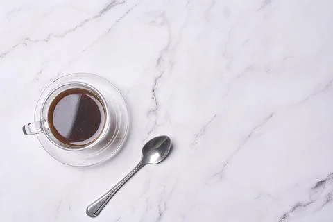 A cup of coffee and a spoon on a table Stock Photos