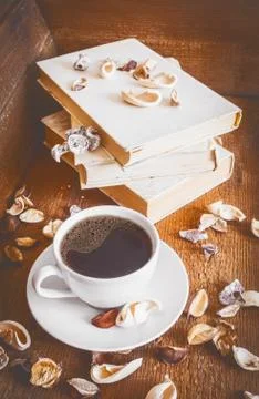 Cup of coffee and stack of old books. Wooden background Stock Photos