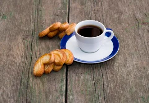 Cup of coffee and two groups of cookies on a wooden table Stock Photos